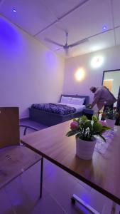 a man in a room with two beds and a table at ELIEL Guesthouse in Parakou