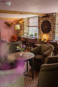 a lobby with chairs and a clock on the wall at Northover Manor Hotel in Ilchester