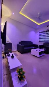 a purple living room with a couch and a tv at ELIEL Guesthouse in Parakou +21 photos