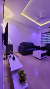 a living room with a couch and a tv at ELIEL Guesthouse in Parakou