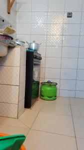 a kitchen with a stove and a green pot at ELIEL Guesthouse in Parakou
