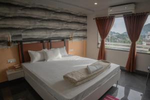a bedroom with a large white bed and a window at Divine View- Boutique Stay in Guwahati