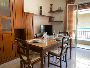 a wooden dining room table with chairs and a television at Casetta in Centro in San Salvo