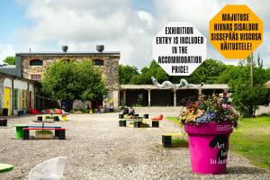 a park with a large pink pot of flowers and signs at Viscosa Hotell in Kõrgessaare