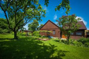 a house in a yard with a green lawn at Agroturystyka Pod Lipą in Iwaniska