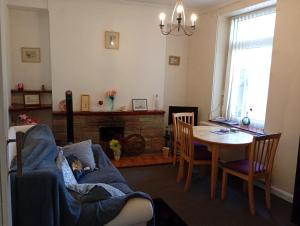 a living room with a table and a couch and a dining room at House near beach in Port Talbot