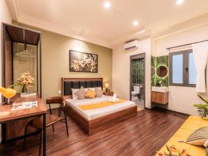 a bedroom with a bed and a table and a desk at Gon De Home Ham Nghi in Ho Chi Minh City