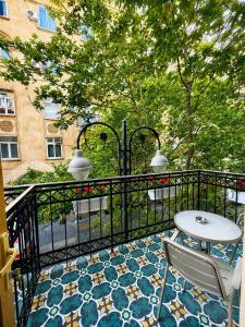 a balcony with a table and chairs on a tile floor at Amara Boutique in Baku