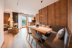 a living room with a table and a couch at AlpeLuce Mountain Chalet in Arabba