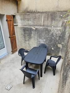 a black table and chairs on a patio at Petite maison design proche centre ville in Cusset
