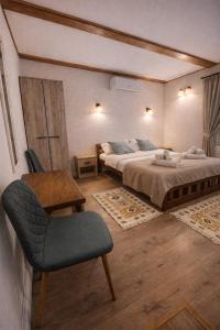 a bedroom with two beds and a chair and a table at Casa Vonvea in Ocna Şugatag