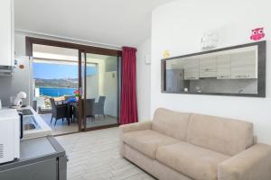 a living room with a couch and a dining room at NRH Cannigione Sunrise Rooftop in Cannigione