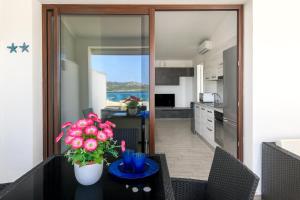 a kitchen with a table with flowers on it at NRH Cannigione Sunrise Rooftop in Cannigione