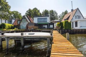 a house on a dock with a boat on the water at Panoramablick am Steinhuder Meer in Steinhude