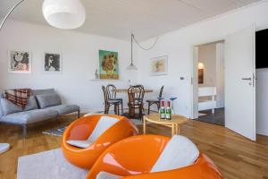 a living room with an orange chair and a table at Panoramablick am Steinhuder Meer in Steinhude