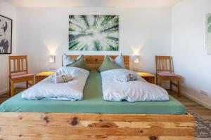 a bed with two pillows on it with two chairs at Panoramablick am Steinhuder Meer in Steinhude