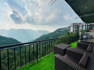 a balcony with chairs and a view of the mountains at Sunset View Luxury Apartments in Nathia Gali