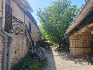 an alley with flowers on the side of a building at Lo Castel de Lasmaries in Saint-Parthem