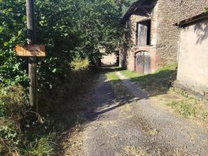 a dirt road next to a building with a sign at Lo Castel de Lasmaries in Saint-Parthem