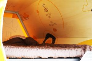 a bed in a room with a wall with drawings on it at Slaaptrailer MXGP Arnhem in Arnhem