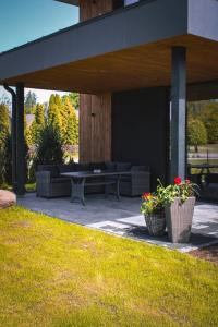a patio with a couch and a table and some plants at Green Guest House in Sigulda