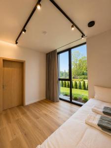 a bedroom with a bed and a large window at Green Guest House in Sigulda