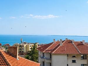 a view of roofs of buildings and the ocean at KITA - Rooms with Sea View in Sveti Vlas