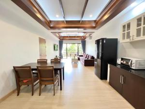 a kitchen and living room with a table and chairs at Panya Samui in Choeng Mon Beach