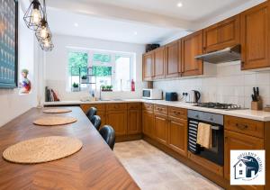 a kitchen with wooden cabinets and a wooden table at Reading 3BR Contractor Accommodation, Sleeps 6, Near Oracle, Free Parking in Reading