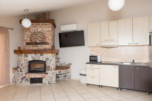 a kitchen with a stone fireplace in a room at Apartments Ribarica in Karlobag