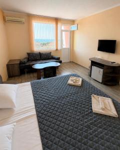 a hotel room with a bed and a living room at KITA - Rooms with Sea View in Sveti Vlas +3 photos