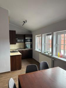 a kitchen with a table and chairs in a room at Apartament Piętrowy 138m2 in Gniezno +16 photos