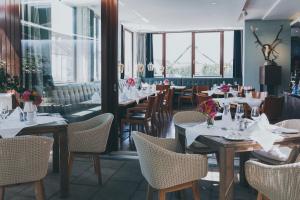 a restaurant with tables and chairs and windows at Das Wildeck Hotel & Restaurant in Abstatt