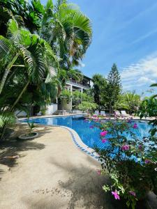 a resort swimming pool with flowers and palm trees at Panya Samui in Choeng Mon Beach