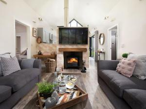 a living room with two couches and a fireplace at Summerset Lodge in Bamburgh