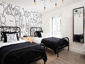 a bedroom with two beds and a mural of people at Summerset Lodge in Bamburgh