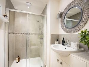a bathroom with a shower and a sink and a mirror at Summerset Lodge in Bamburgh +16 photos