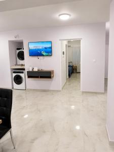 a white living room with a television on a wall at studio room with private bathroom-floor 2 in Athens +8 photos