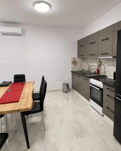 a kitchen with a wooden table and black appliances at studio room with private bathroom-floor 2 in Athens