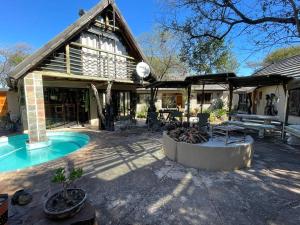 a house with a patio and a swimming pool at Kulilo Lodge in Thabazimbi