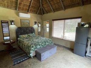 a bedroom with a bed and a refrigerator in it at Kulilo Lodge in Thabazimbi