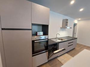 a kitchen with a stainless steel refrigerator and a sink at Appartamento ZUFALL in Cogolo +8 photos