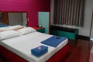 a bed with two blue towels on top of it at Zigzag Resort in Ban Som Poi