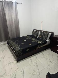 a bedroom with a bed with black and gold sheets at maison soleil in Nouaceur
