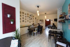 people sitting at tables in a restaurant with a red door at Falling Lakes Hostel in Korenica