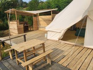 a tent and a picnic table on a wooden deck at Ruhondo Campsite View in Muhororo