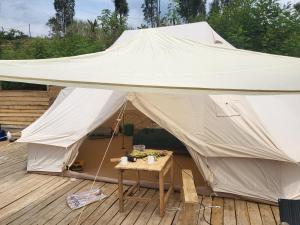 a large tent on a deck with a table at Ruhondo Campsite View in Muhororo
