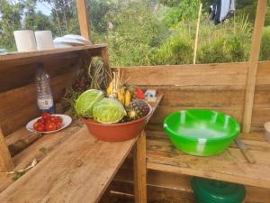 a table with a bowl of fruits and vegetables on it at Ruhondo Campsite View in Muhororo