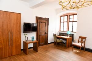 een woonkamer met een bureau en een televisie en een bureau sidx sidx sidx sidx bij Weinhotel Koegler in Eltville