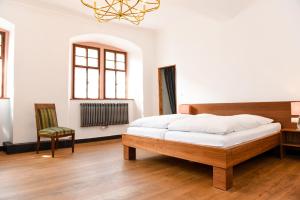 a bedroom with a bed and a desk and a chair at Weinhotel Koegler in Eltville